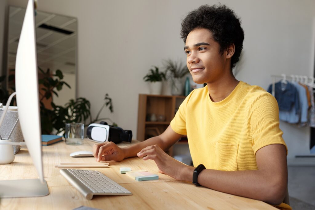 High school boy programming on a desktop computer